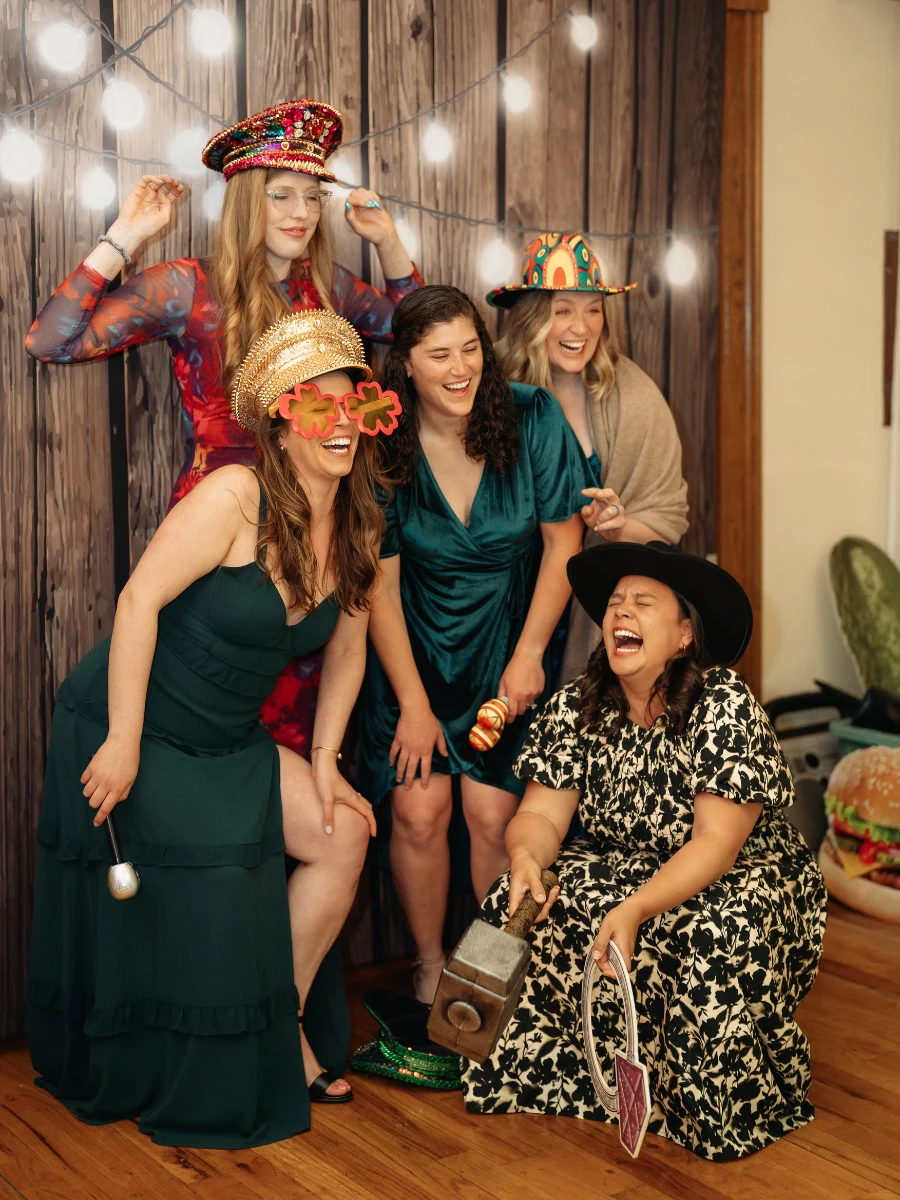 Guests laughing and wearing photo booth props during a wedding in Berthoud, CO