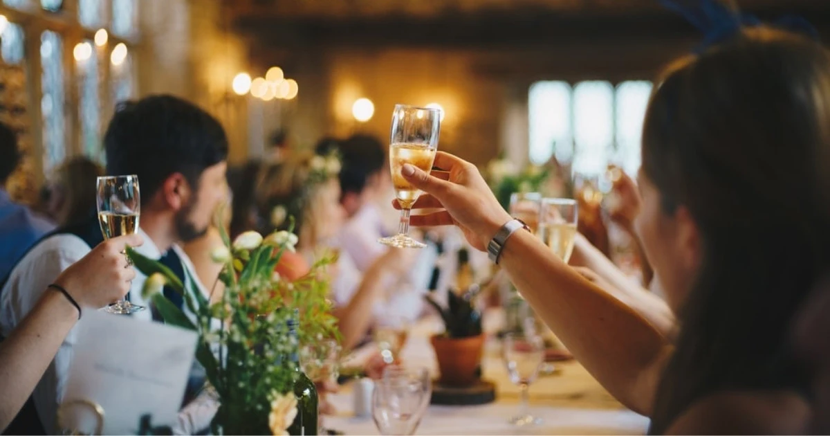Photo taken of guests at a weddings holding up glasses to cheers at an event in Northern Co. Photo booth hosted by CaptureME Photo Booth