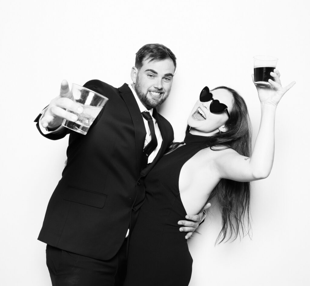 Luxury black and white Glam booth photo of guests having fun at a high-end wedding with black and white printed photos