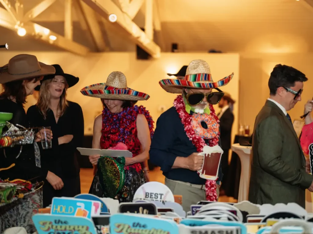 Wedding guests laughing while choosing props at Brookside Gardens reception