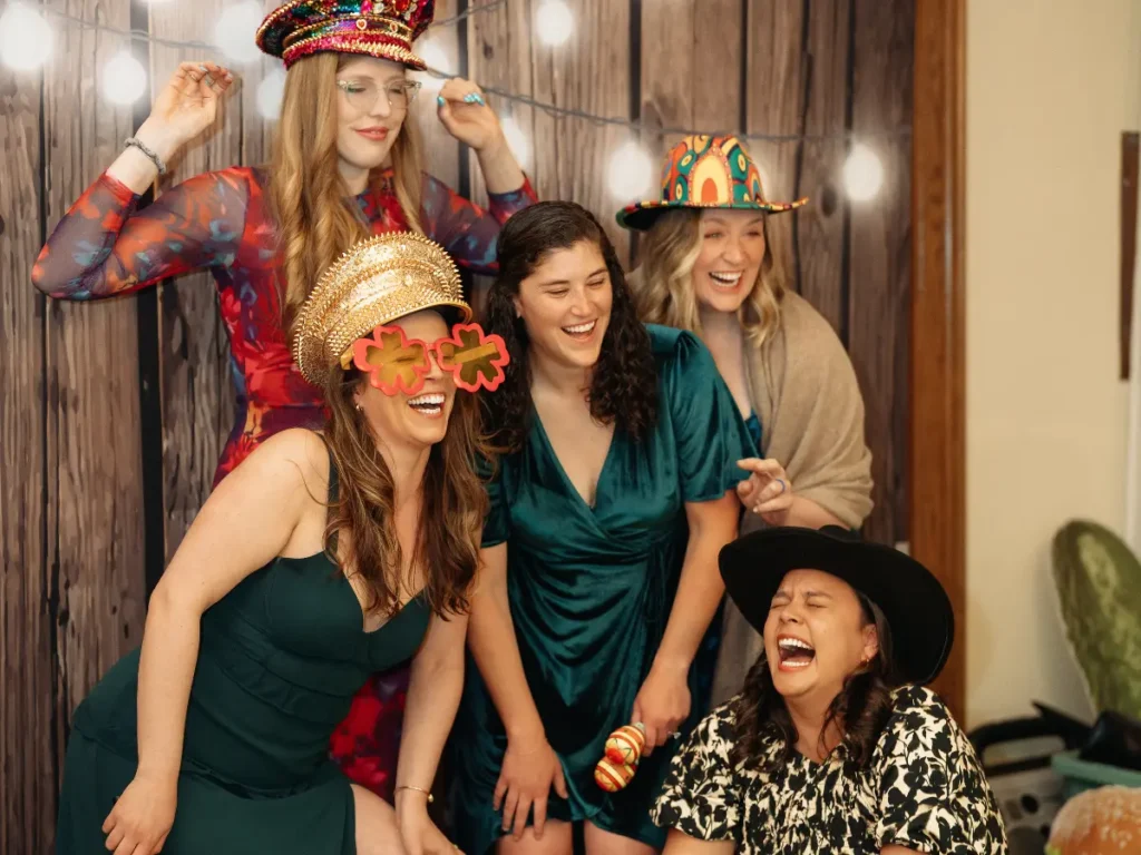 Wedding guests posing with props inside photo booth at Brookside Gardens in Berthoud CO