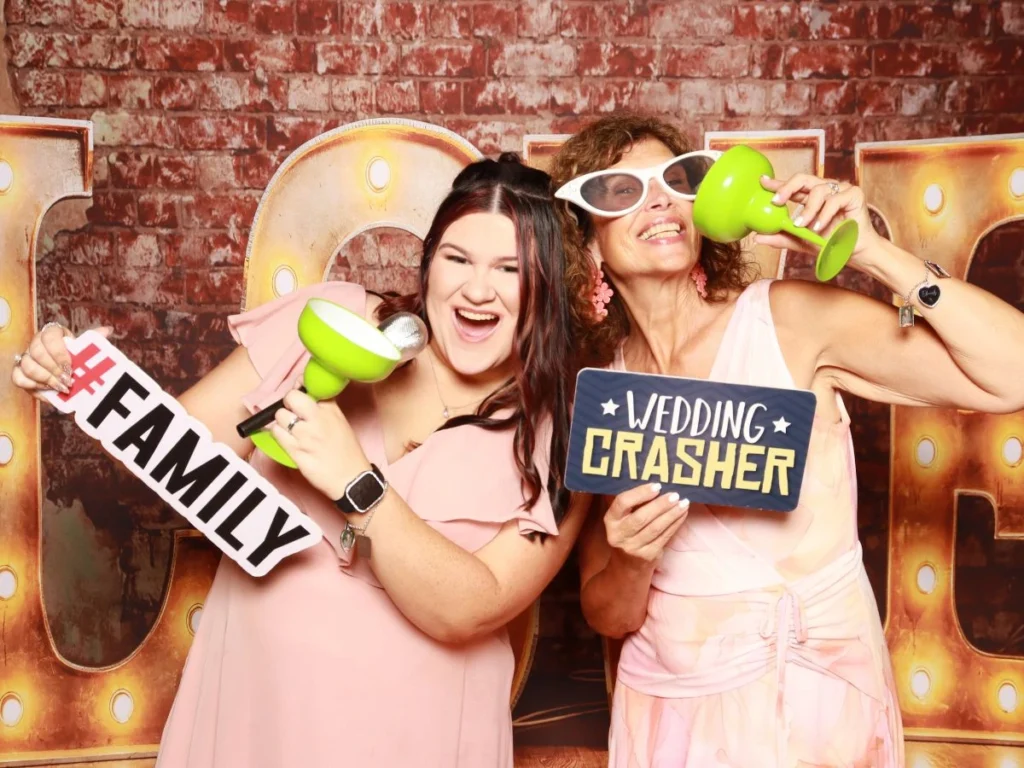 Wedding guests taking photos at a photo booth at Ellis Ranch in Loveland, Colorado